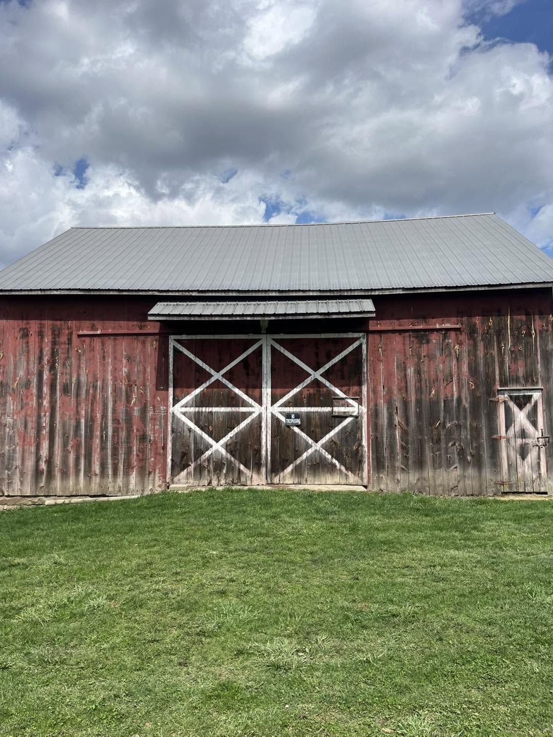 Red bank barn with its metal roof freshly coated