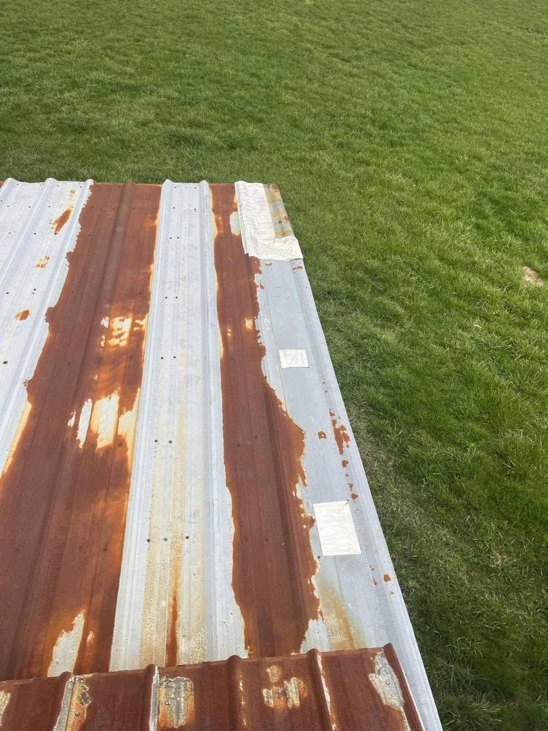 Close-up of rusted metal roof panels before prep
